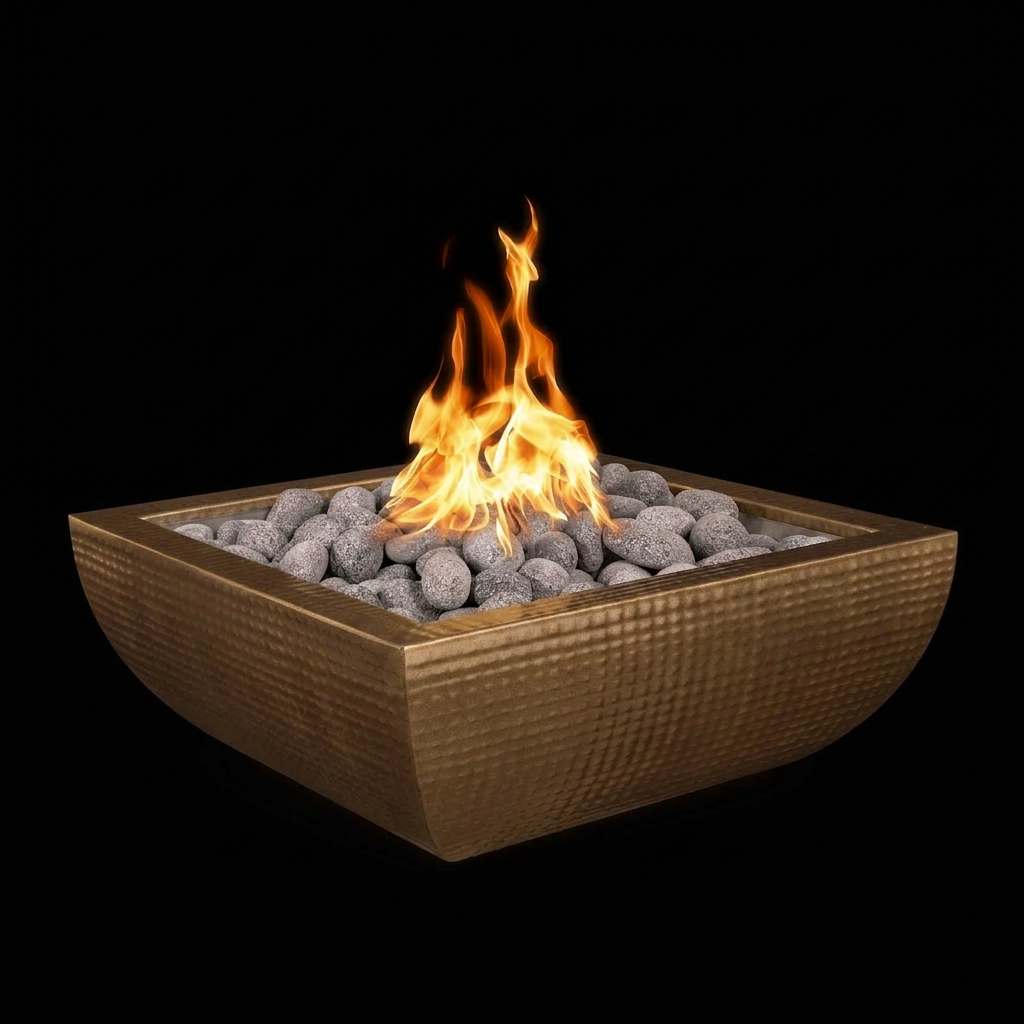A square bronze fire pit bowl filled with gray stones and glowing orange flames, shown against a solid black background.