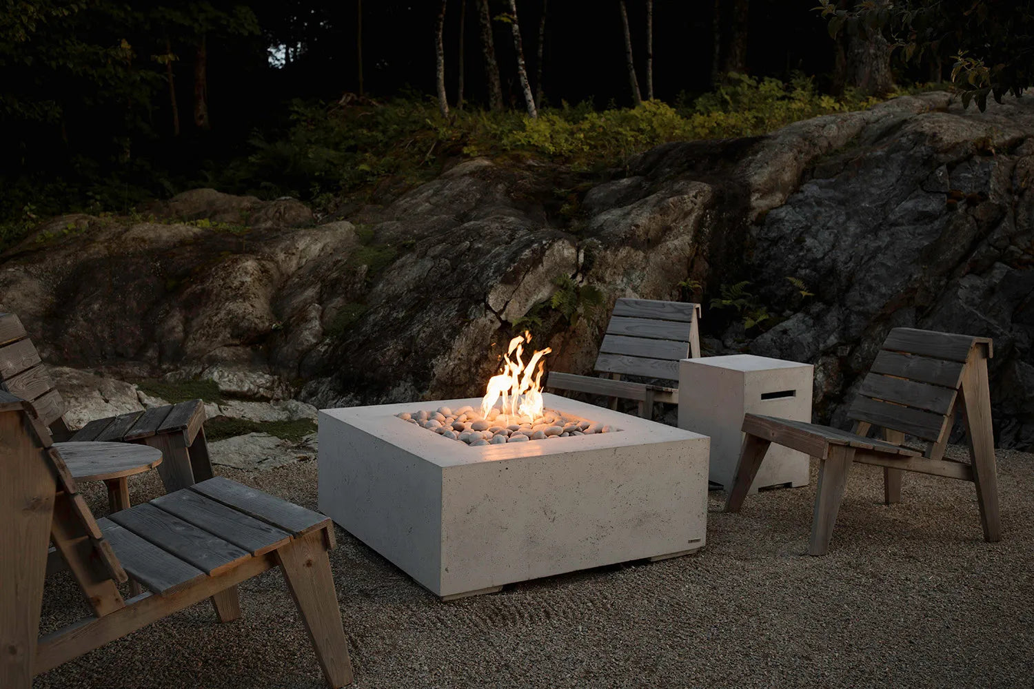 Fire pit with chairs around it in a rocky outdoor setting