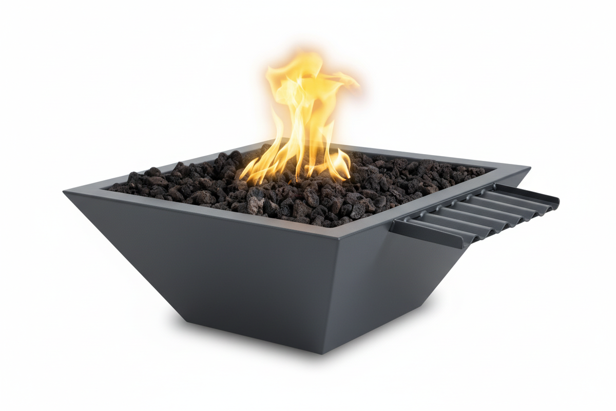 A modern square black fire pit with a side handle, filled with dark river rocks and lit with a bright yellow and orange flame, isolated on a white background.