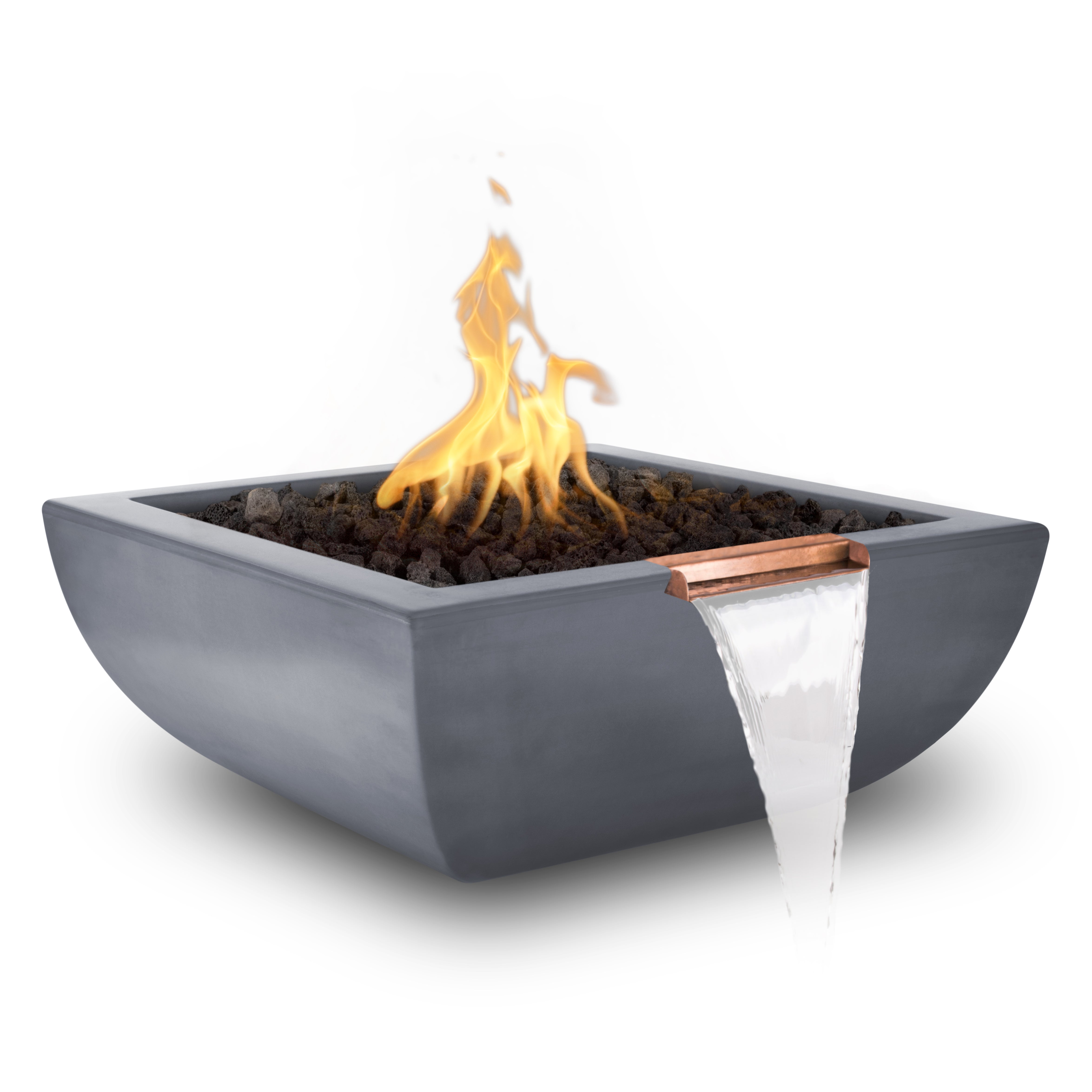 A square gray concrete fire pit with a copper accent trim and a waterfall feature, filled with black lava rocks and lit with yellow-orange flames, shown on a white background.