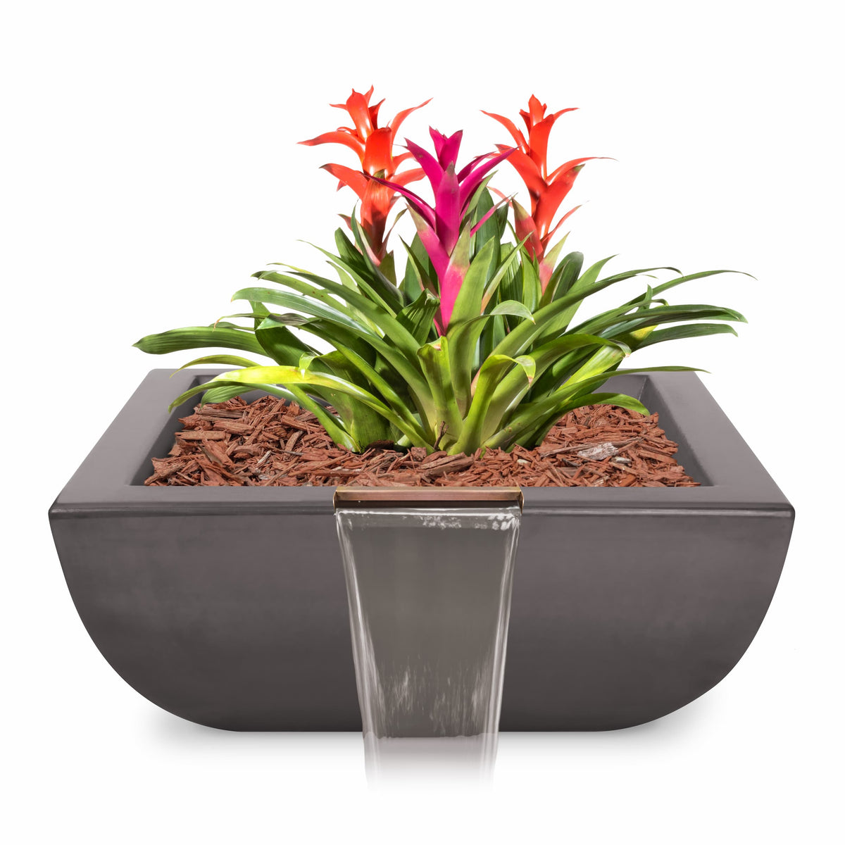 A modern dark gray rectangular planter with a small waterfall feature, filled with brown wood chips, green foliage, and bright red and pink flowers, shown on a white background.