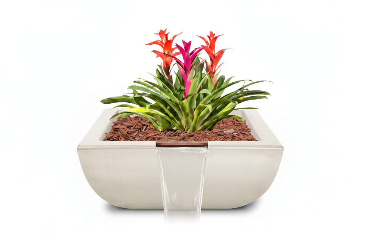 A square white ceramic planter with a waterfall spout, filled with green foliage, red and pink flowers, and brown mulch, shown on a white background.
