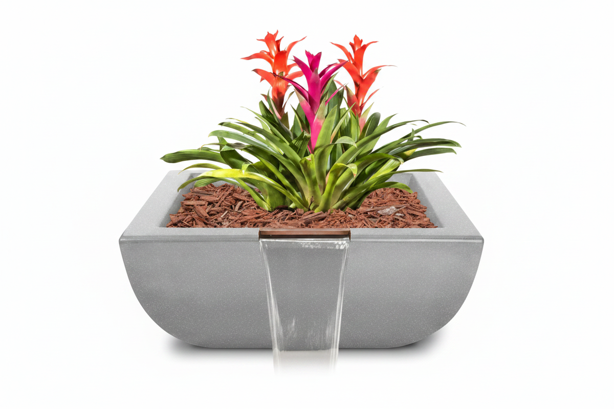 A rectangular concrete planter with a small front waterfall feature, filled with brown mulch and green plants featuring bright orange and magenta flowers, set against a solid white background.