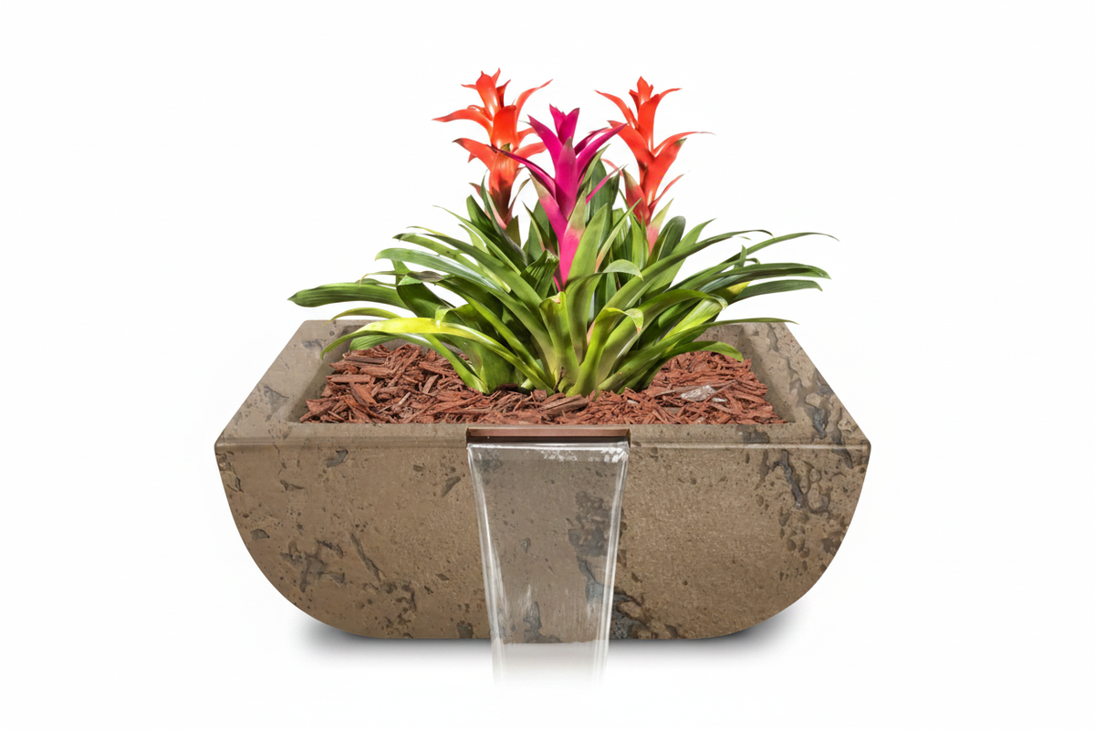 A rectangular concrete planter with a small front waterfall feature, filled with brown mulch and green plants featuring bright orange and magenta flowers, set against a solid white background.
