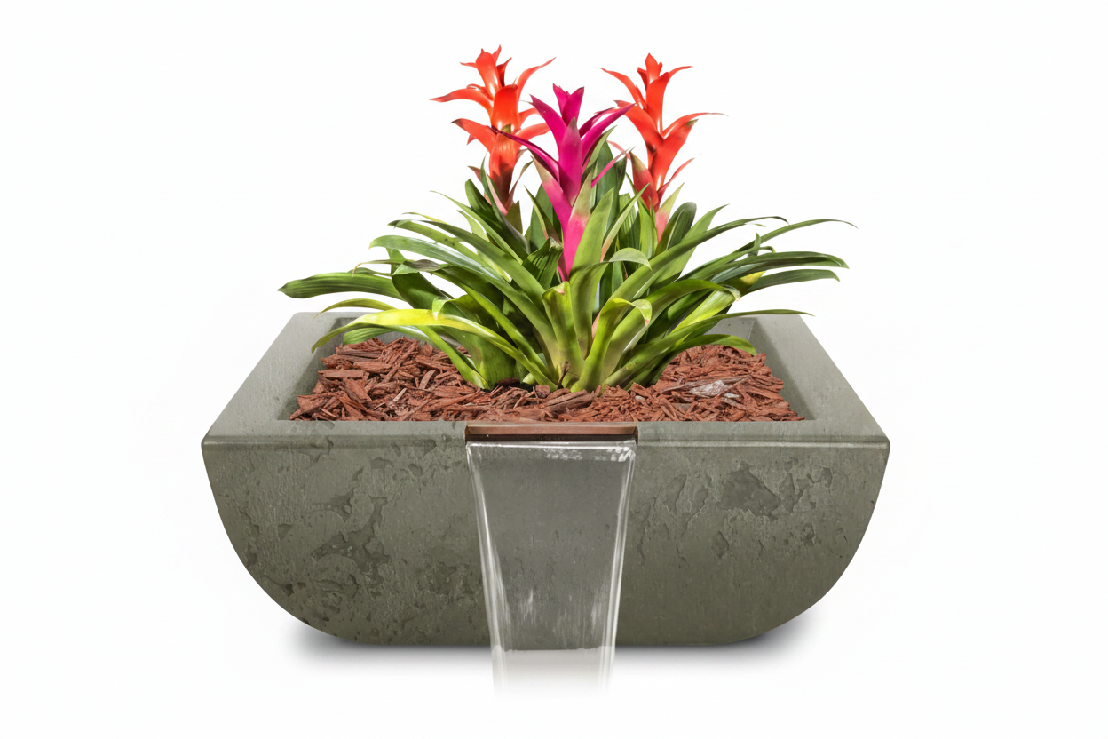 A rectangular gray concrete planter with a small waterfall feature, filled with green foliage and bright orange and pink flowers, set against a plain white background.