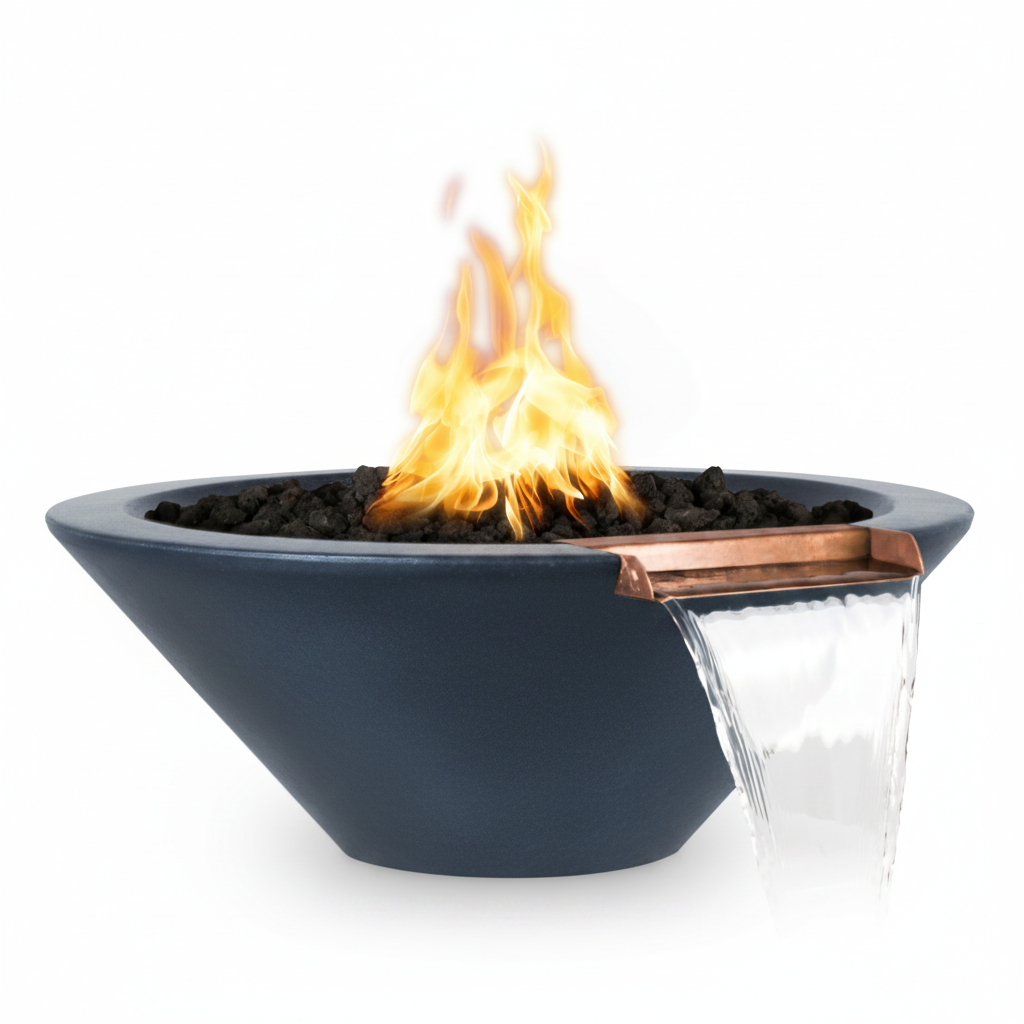 A modern outdoor fire pit bowl in matte dark blue-gray, filled with black river rocks and showing a bright orange flame. A copper-colored metal spout on the side pours water into a clear glass tray below, set against a solid white background.