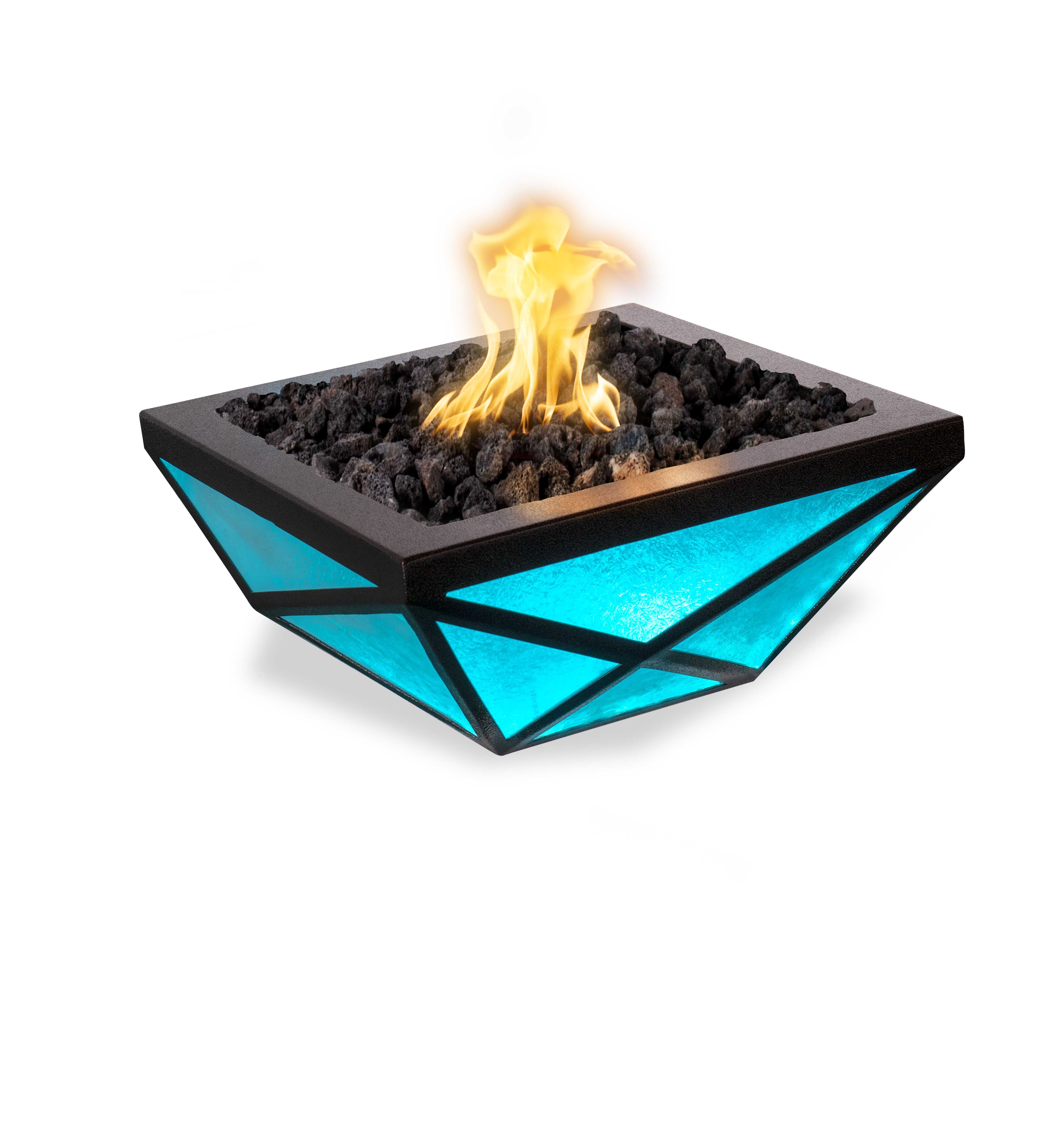 A modern geometric fire pit table with a black frame, glowing turquoise blue glass panels, and black lava rocks with a bright yellow-orange flame, isolated on a white background.