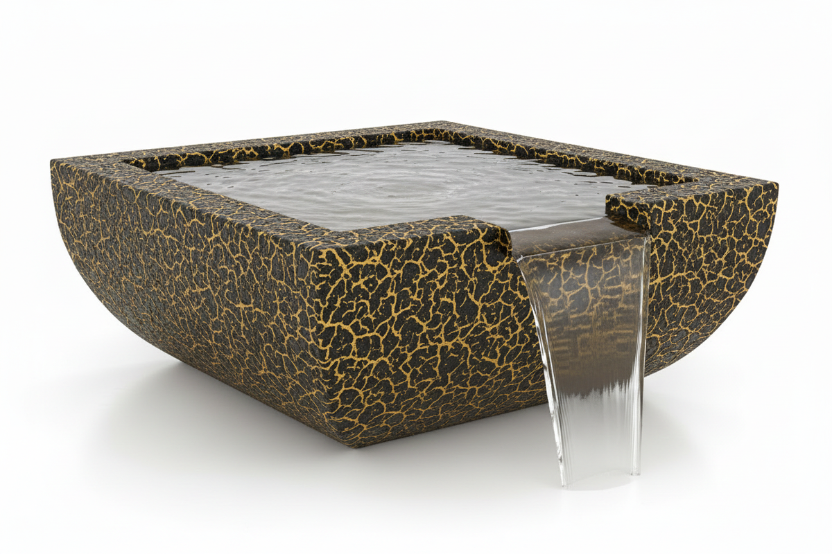 A square outdoor water fountain with a dark textured body featuring a gold crackle pattern, containing clear water with a transparent glass waterfall spout, shown on a white background.
