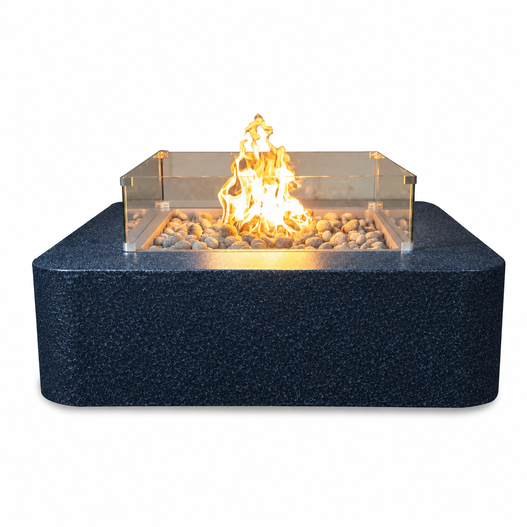 A modern square fire pit table with a dark textured base, clear acrylic wind guard, and glowing fire with pebbles inside, shown on a plain white background.