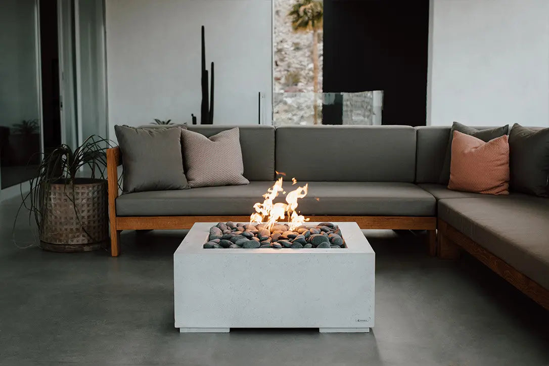 Modern outdoor living space with a fire pit table and sectional sofa.