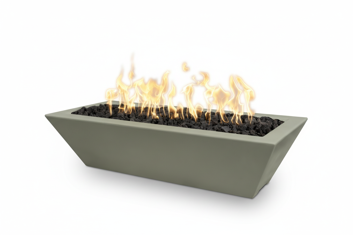A rectangular concrete fire pit with a modern tapered design, filled with black decorative stones and active orange and yellow flames, shown on a solid white background.