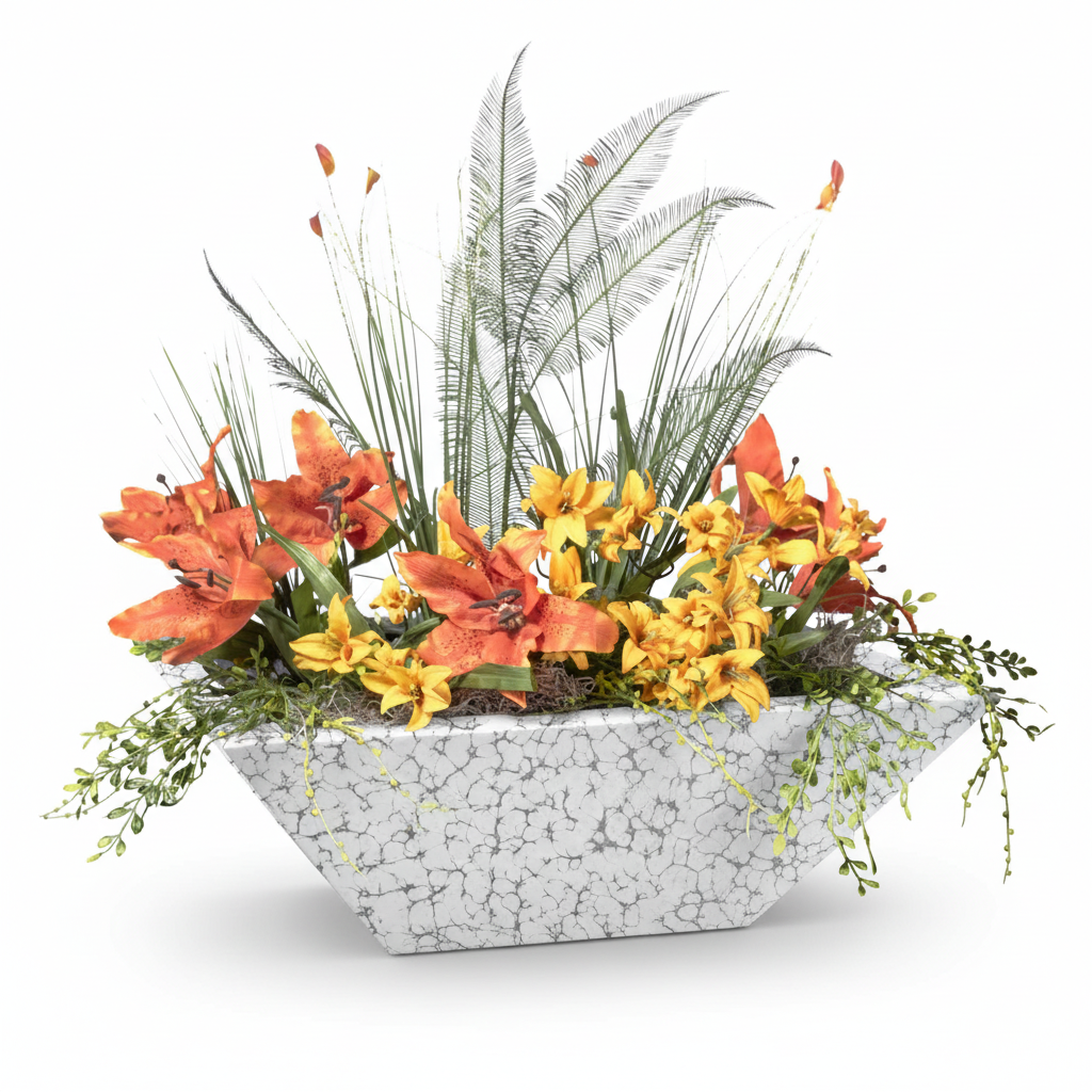A modern geometric planter with a white and gray crackle stone pattern, filled with a vibrant floral arrangement featuring orange and yellow lilies, green foliage, and tall palm-leafy stems, set against a plain white background.