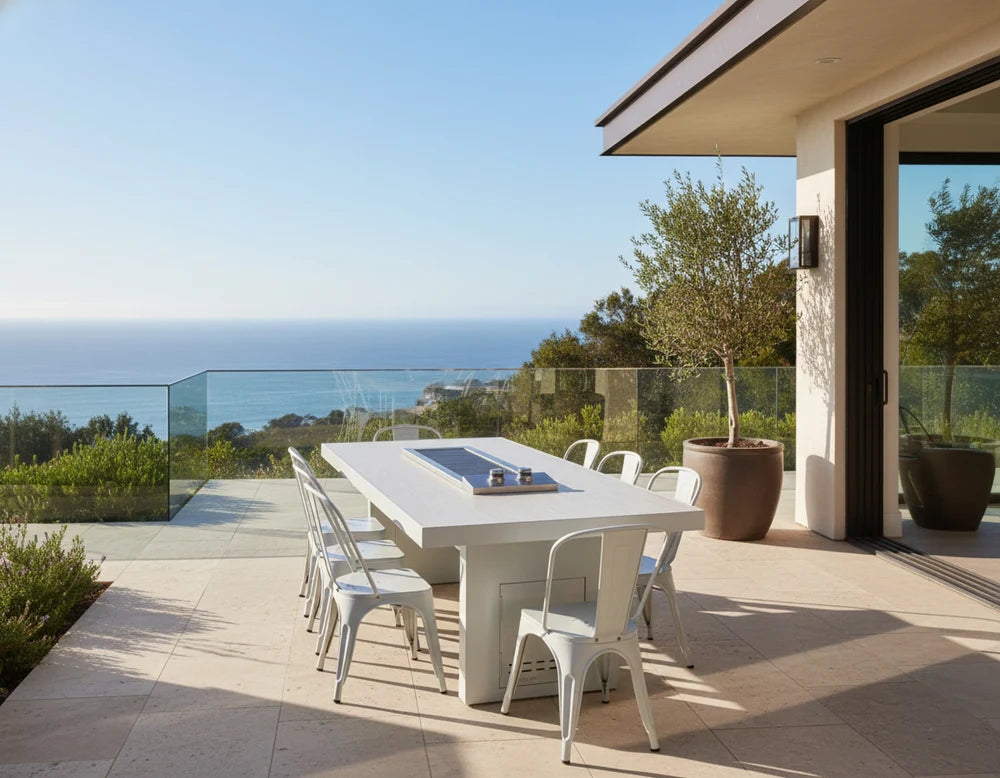 Santa Barbara Cooking Table by The Outdoor Plus in white powder coat finish with matching metal chairs on a luxury oceanview patio

