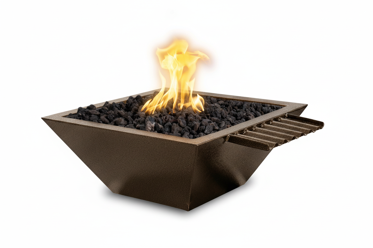 A square outdoor fire pit with a dark bronze metal frame, filled with black lava rocks and lit with a bright yellow-orange flame, shown on a solid white background.