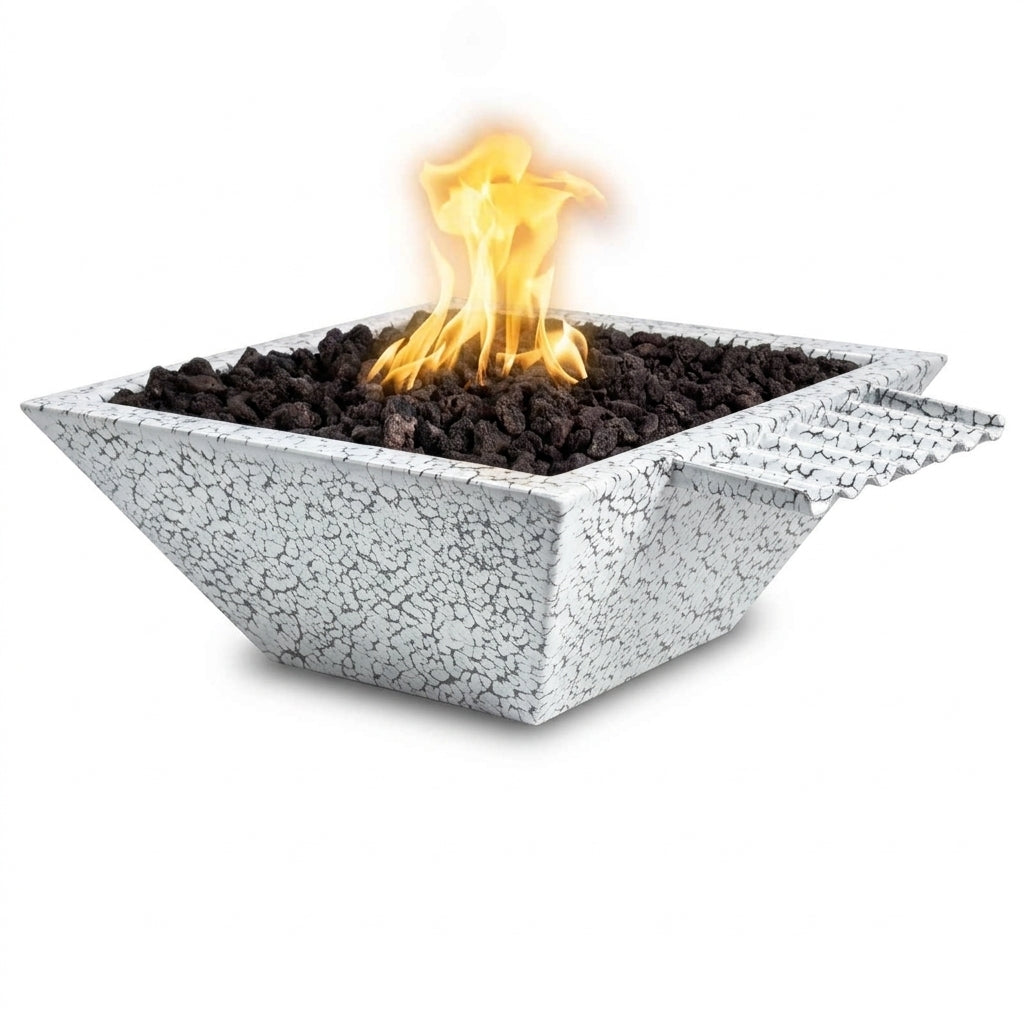 A square concrete fire pit with a textured, crackled light gray finish, filled with dark river rocks and lit with a bright orange and yellow flame, shown against a solid white background.